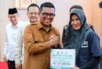 Gubernur Banten, Andra Soni saat menyerahkan bantuan Tali Asih dari BAZNAS Provinsi Banten kepada Penerima Manfaat. Foto: ist