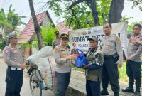 Kapolsek Neglasari AKP Imron Mas’adi saat membagikan paket sembako kepada warga. Foto: Ist