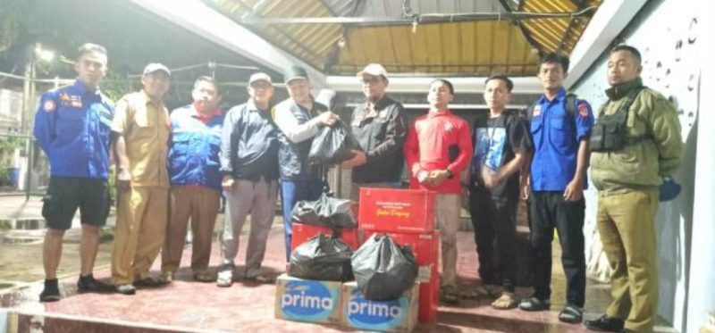 Petugas Dinas Sosial membagikan bantuan untuk warga yang terdampak banjir. Foto: Ist